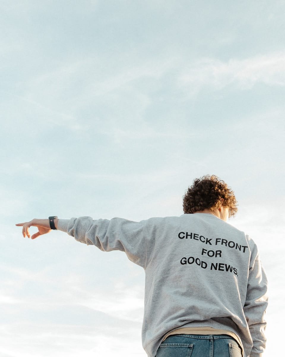 man in gray long sleeve shirt holding black smartphone